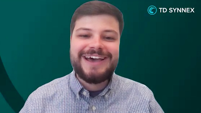 Grant Smith smiling, wearing a collared shirt with the TD SYNNEX logo in the background