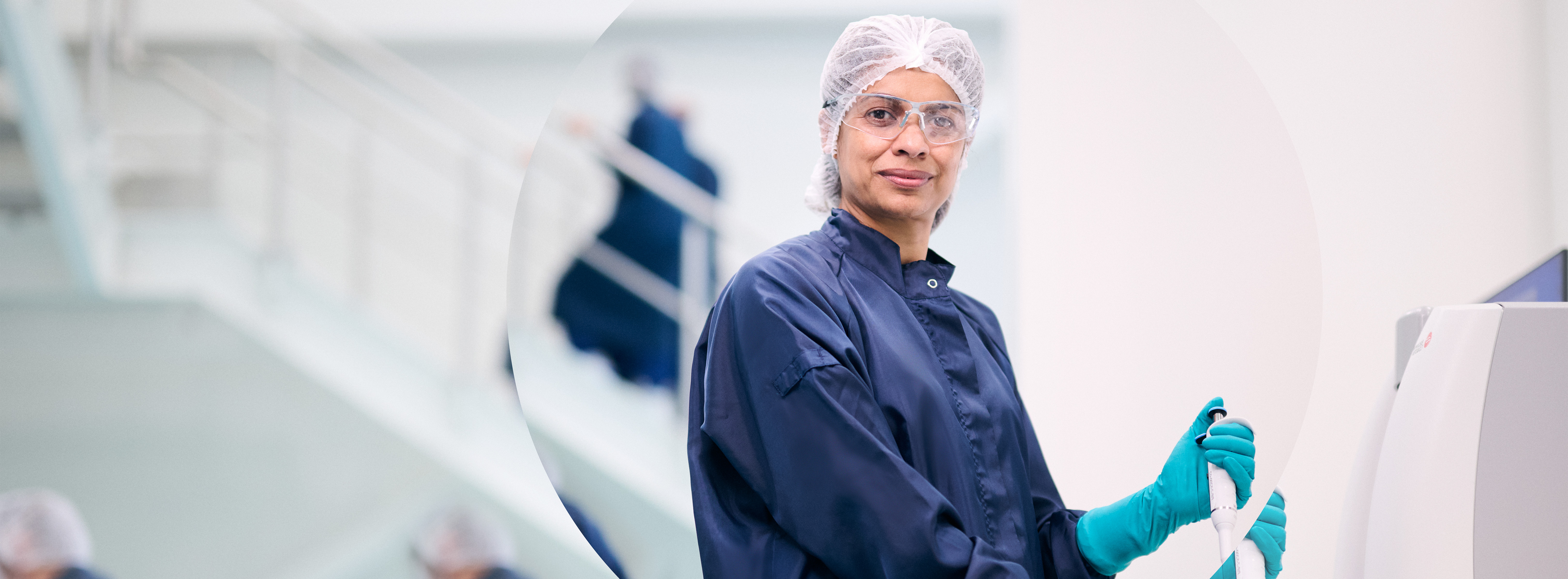 Person in safety goggles and hairnet in manufacturing setting