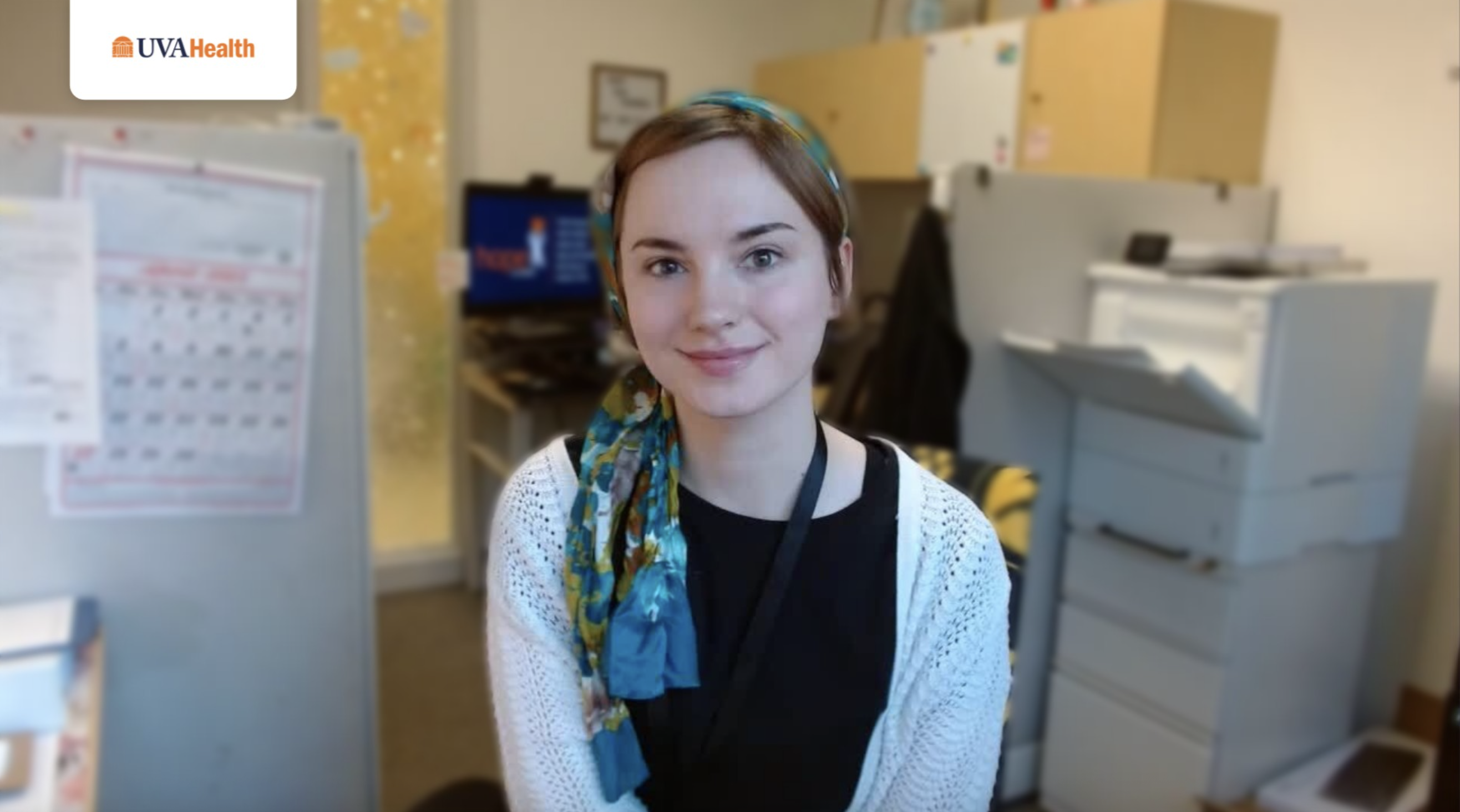 Person looks directly at camera in office setting.