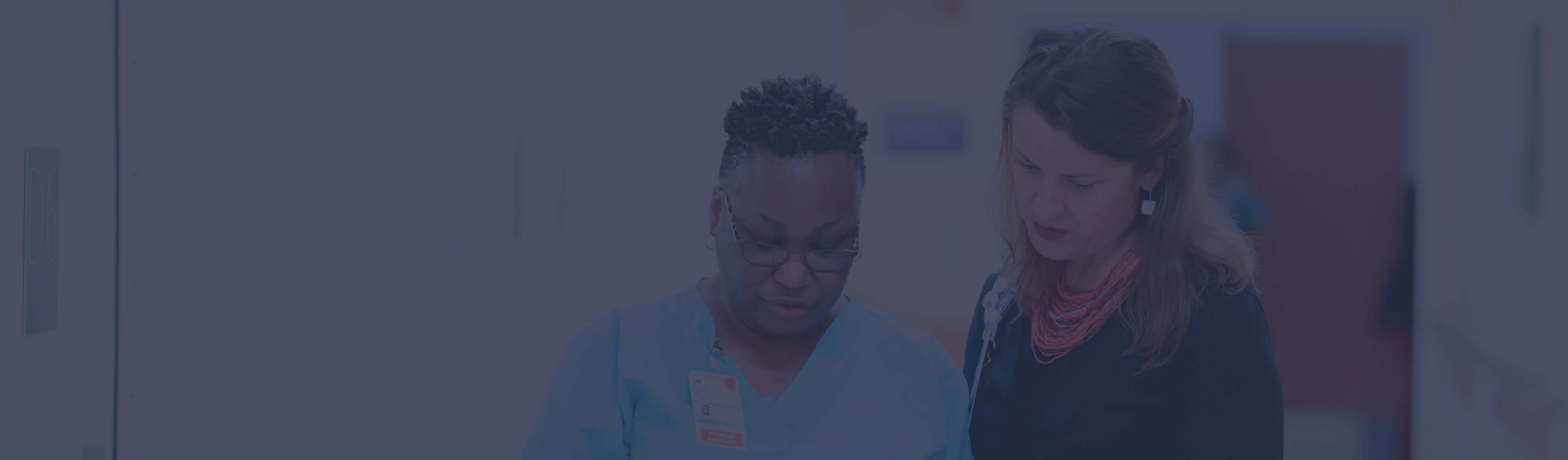Two hospital professionals talking in hallway