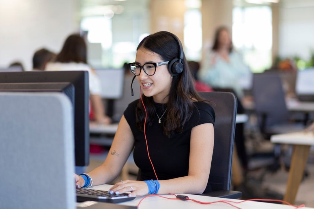 Chica de atención al cliente frente a un ordenador.