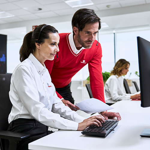Trabajadores de atención al cliente frente a pantalla.
