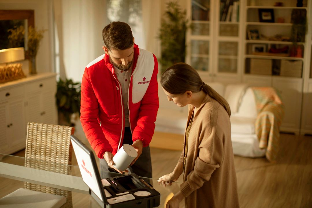 Comercial de Verisure enseñando alarma a una cliente