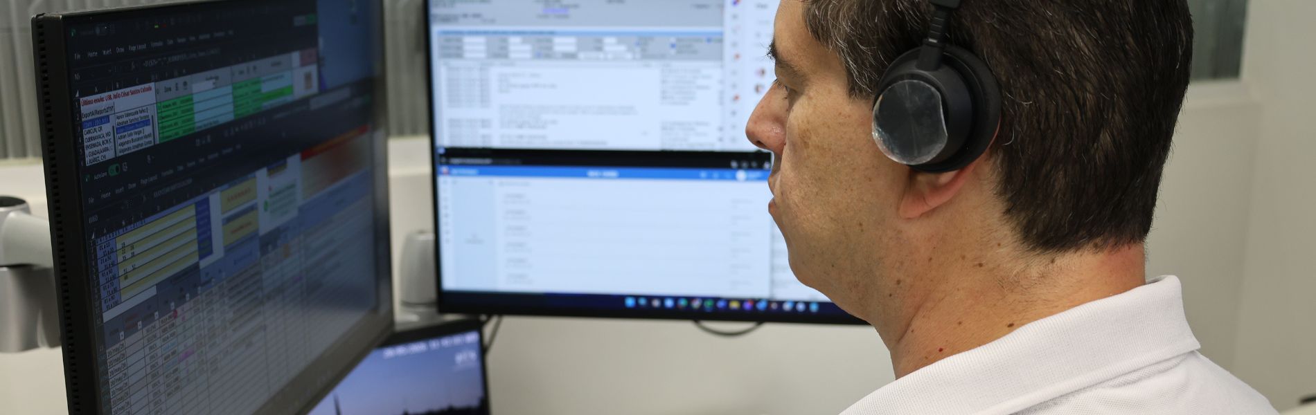 Empleado de ADT viendo datos en pantalla de ordenador.