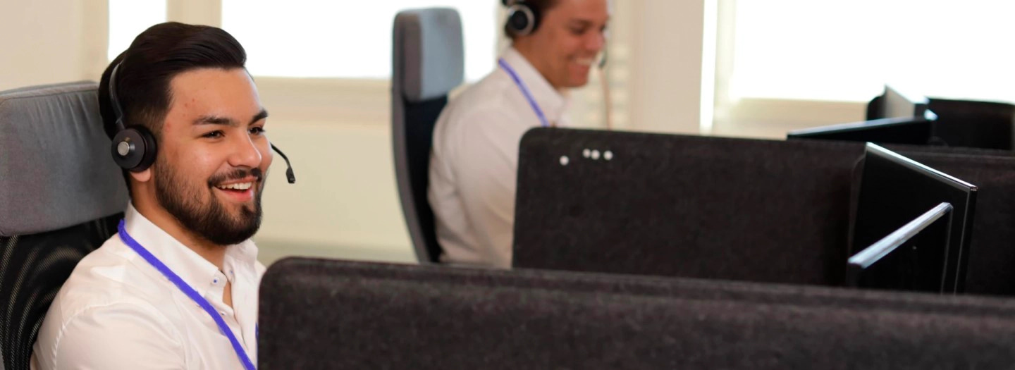 Chico de atención al cliente sonriendo.