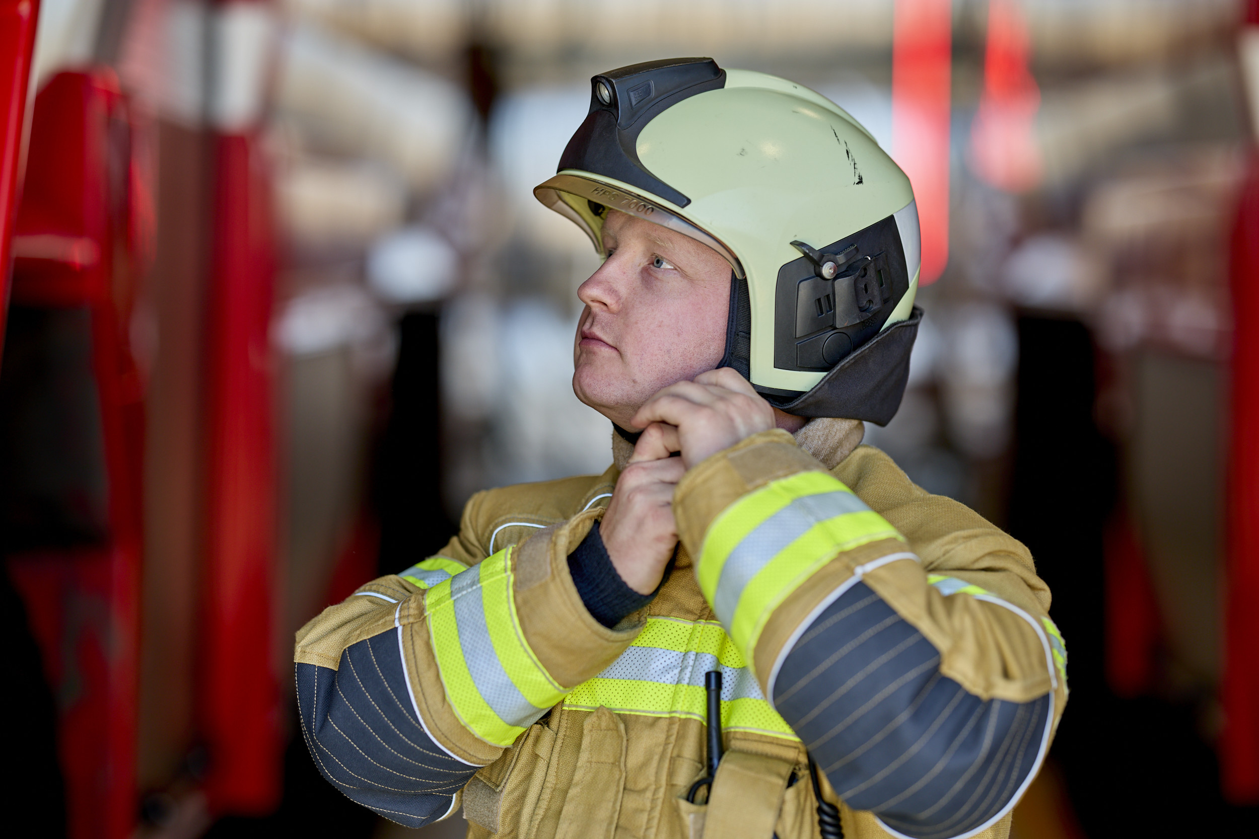 Firefighter in uniform putting helmet on