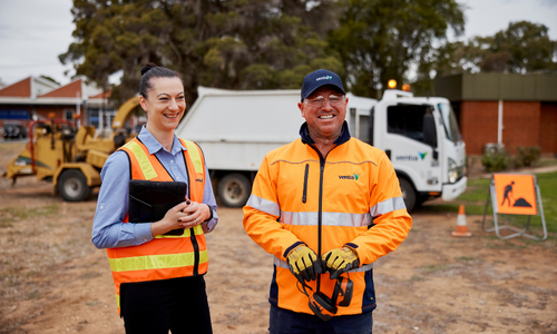 Two people in orange hi vis smiling