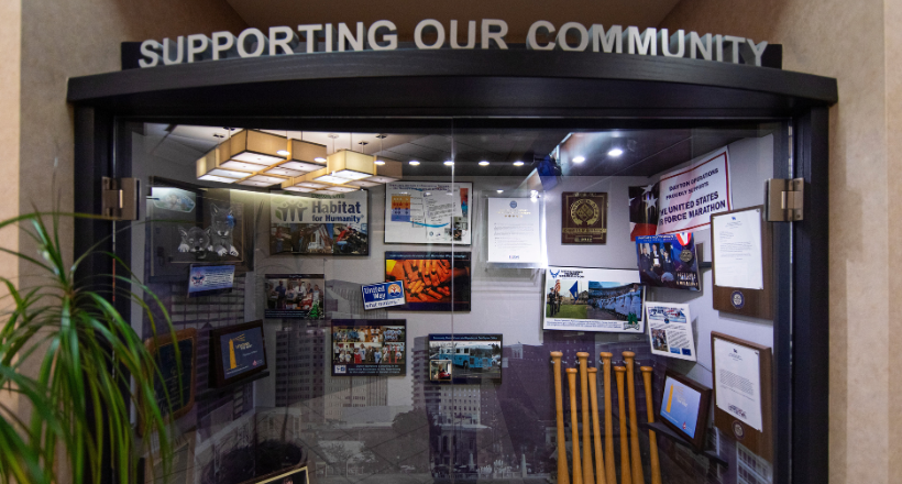 Glass case at the BAE Systems facility in Dayton, Oh showcasing various community investment efforts.