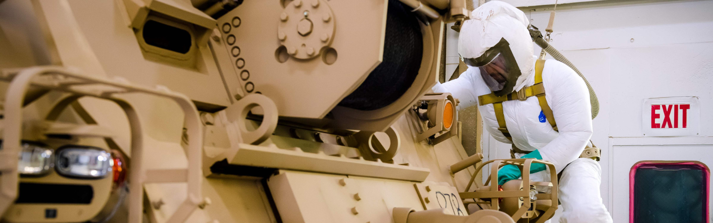 Painter works on a combat vehicle.