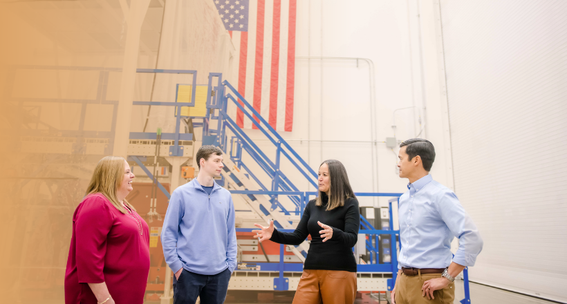 Four SMS employees have a discussion at a BAE Systems facility in Boulder, CO.