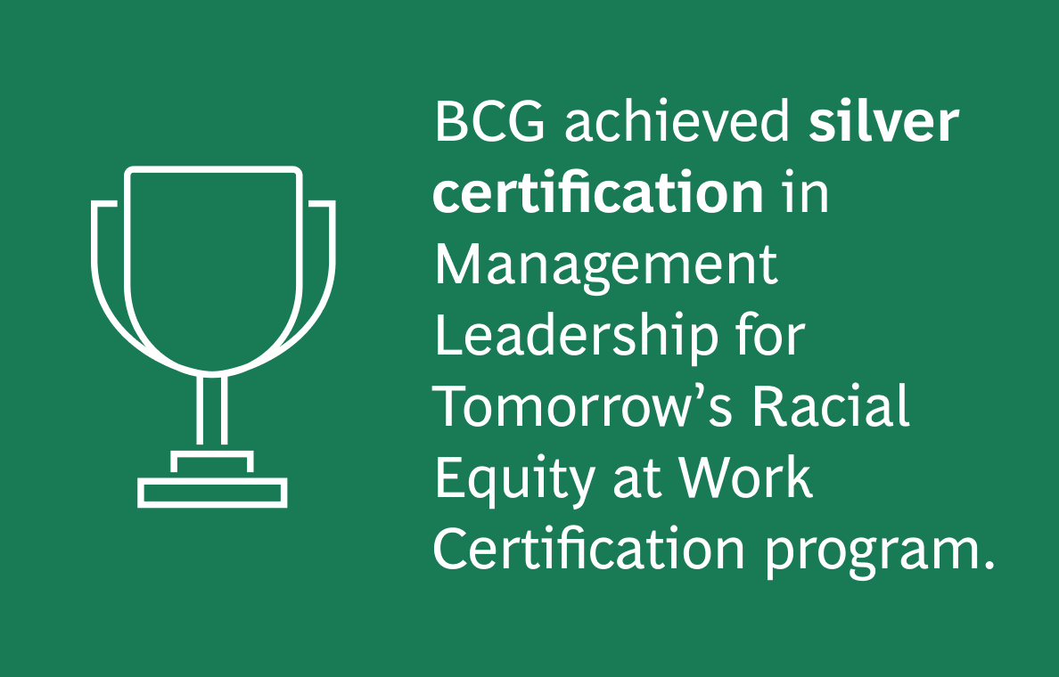 The image has a dark green background with the following text:  BCG achieved silver certification in Management Leadership for Tomorrow’s Racial Equity at Work Certification program.  On the left side of the image, there is a white outline icon of a trophy, representing achievement. The text is white, with "silver certification" in bold for emphasis. The icon is on the left, and the text is aligned to the right of the icon.