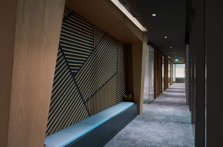 A hallway with angular wooden paneling and modern lighting, creating a professional and contemporary atmosphere.