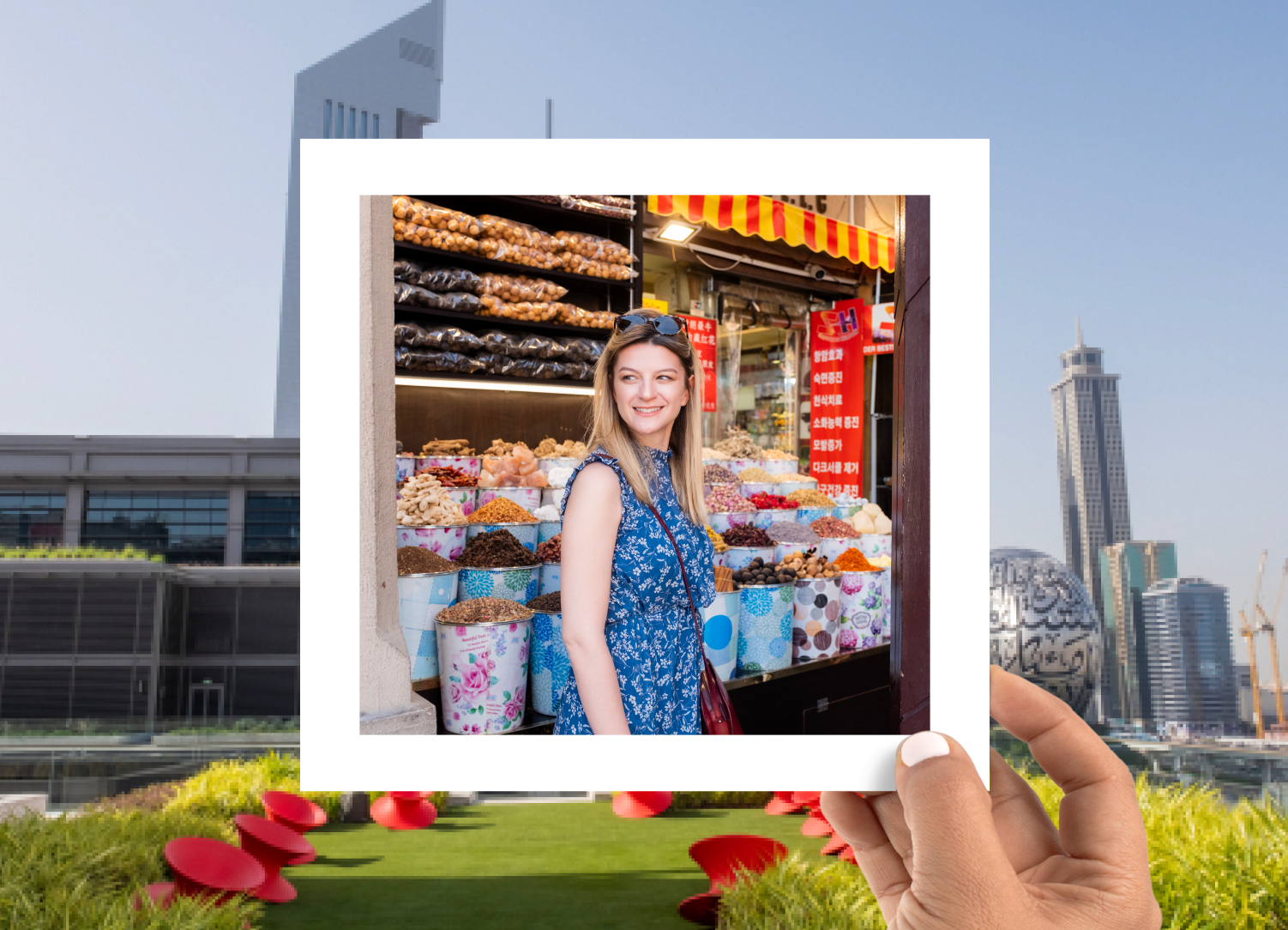 A vibrant market scene with a woman in a blue floral dress smiling near colorful bins of dried goods, framed in a polaroid-style overlay with Dubai's futuristic skyline in the background.