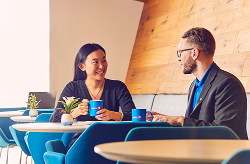 Two young employees having coffee break.