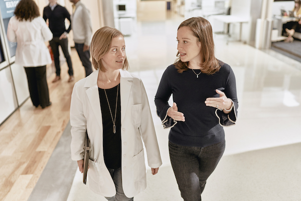 Two women talking and walking