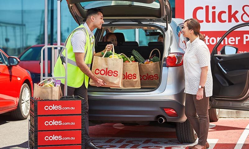A Coles team member helping load groceries into a customer's car