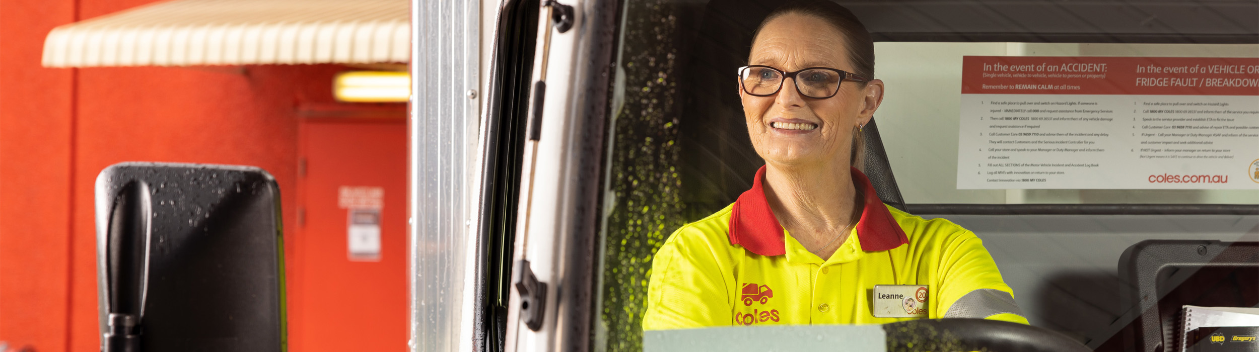 Female Coles customer service agent driving a truck