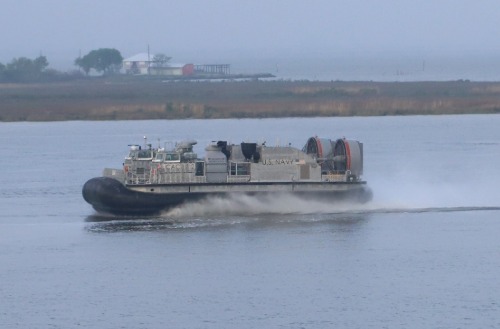 U.S. Navy hovercraft developed by Textron Systems traveling across calm coastal waters.