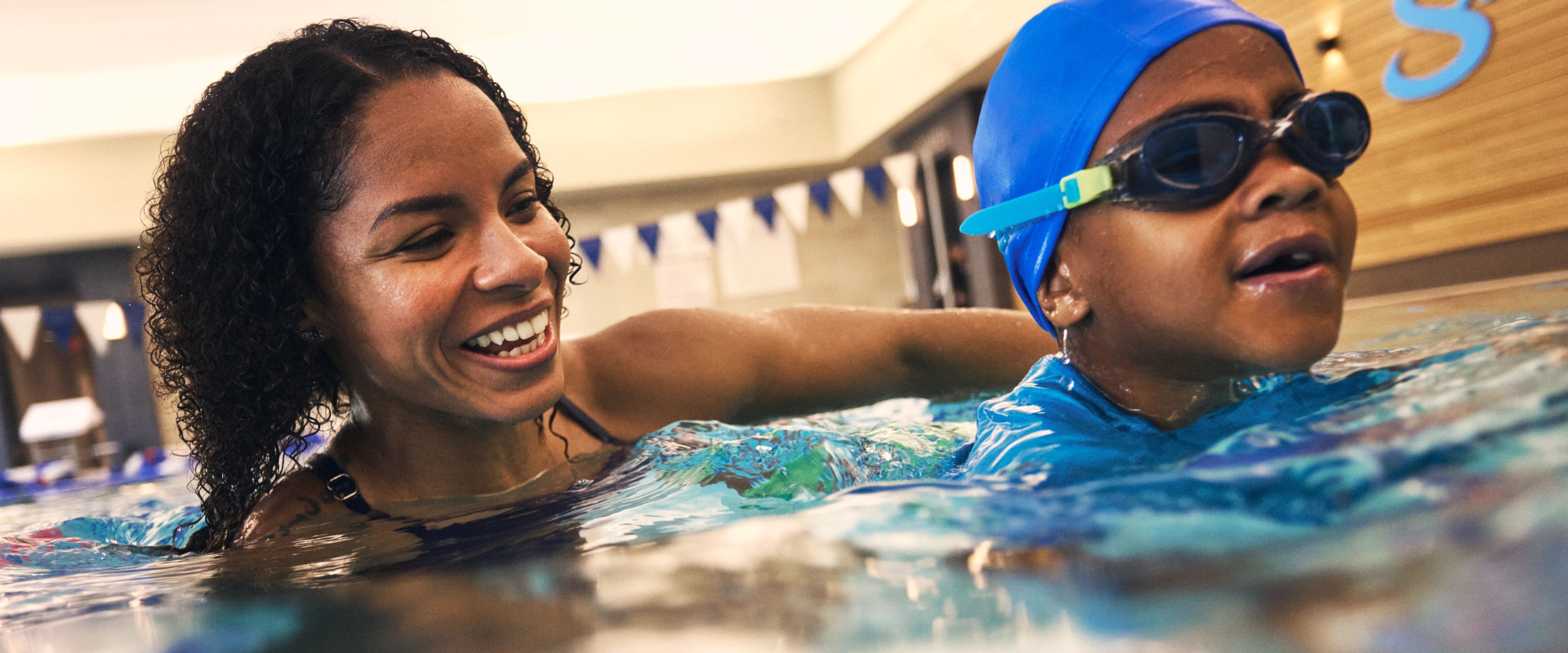 Life Time swim instructor teaching a child how to swim in the pool.