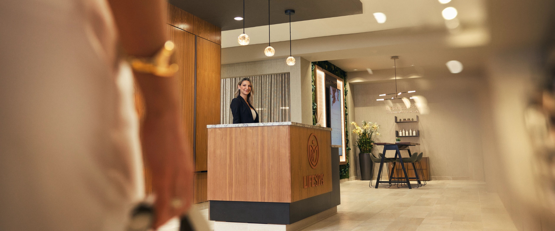 Life Time Spa team at the front desk of the spa greeting a client.