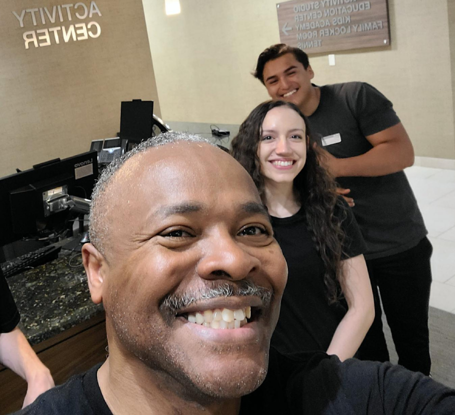 Veteran smiling with his Life Time coworkers.