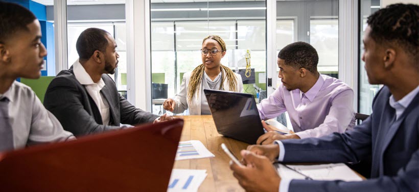 A photo of a group of employees sitting around a conference table