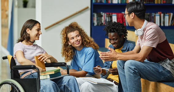 Four students talking in a library.