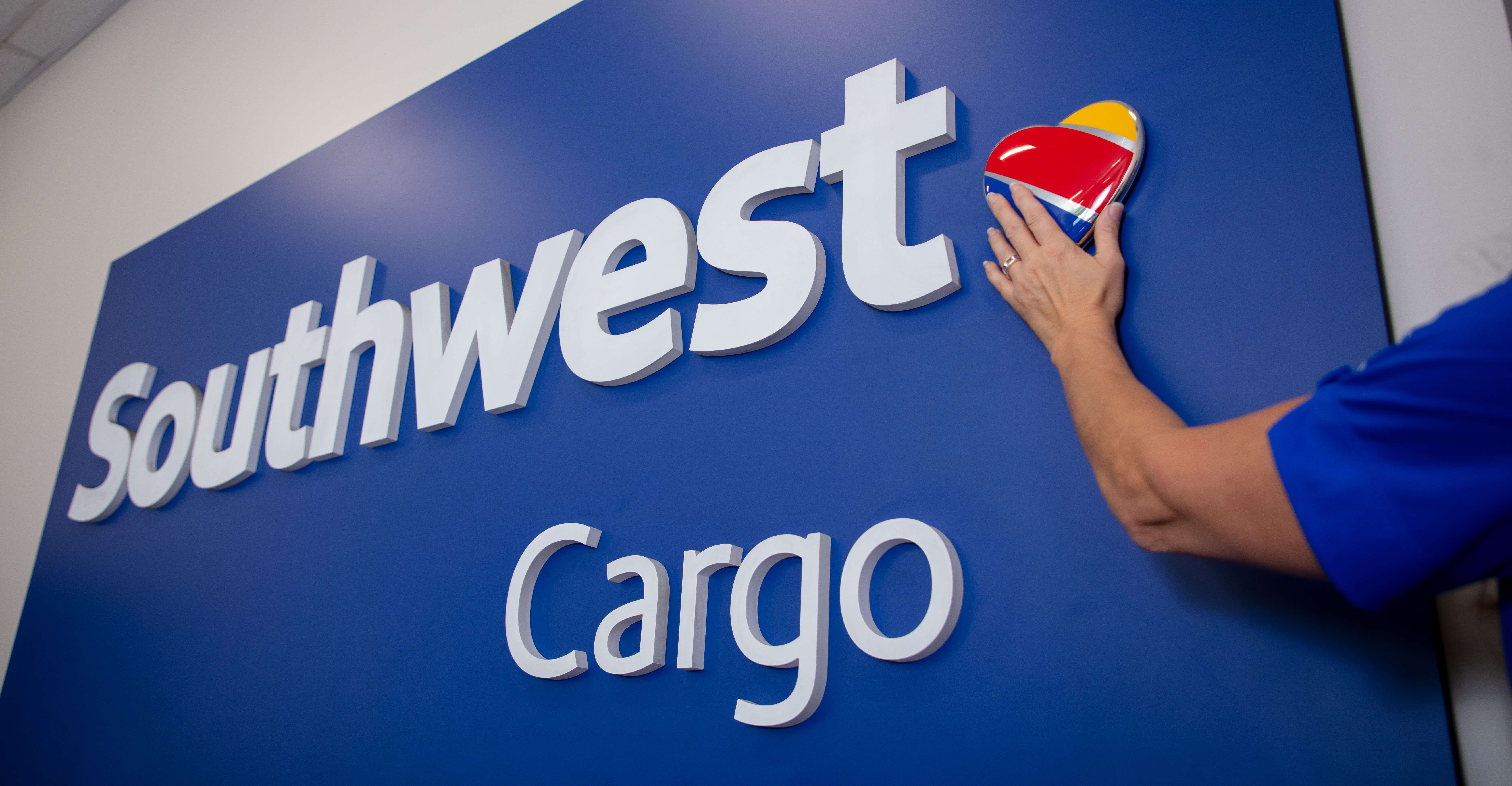 Southwest Cargo sign with Employees hand touching the Southwest logo.