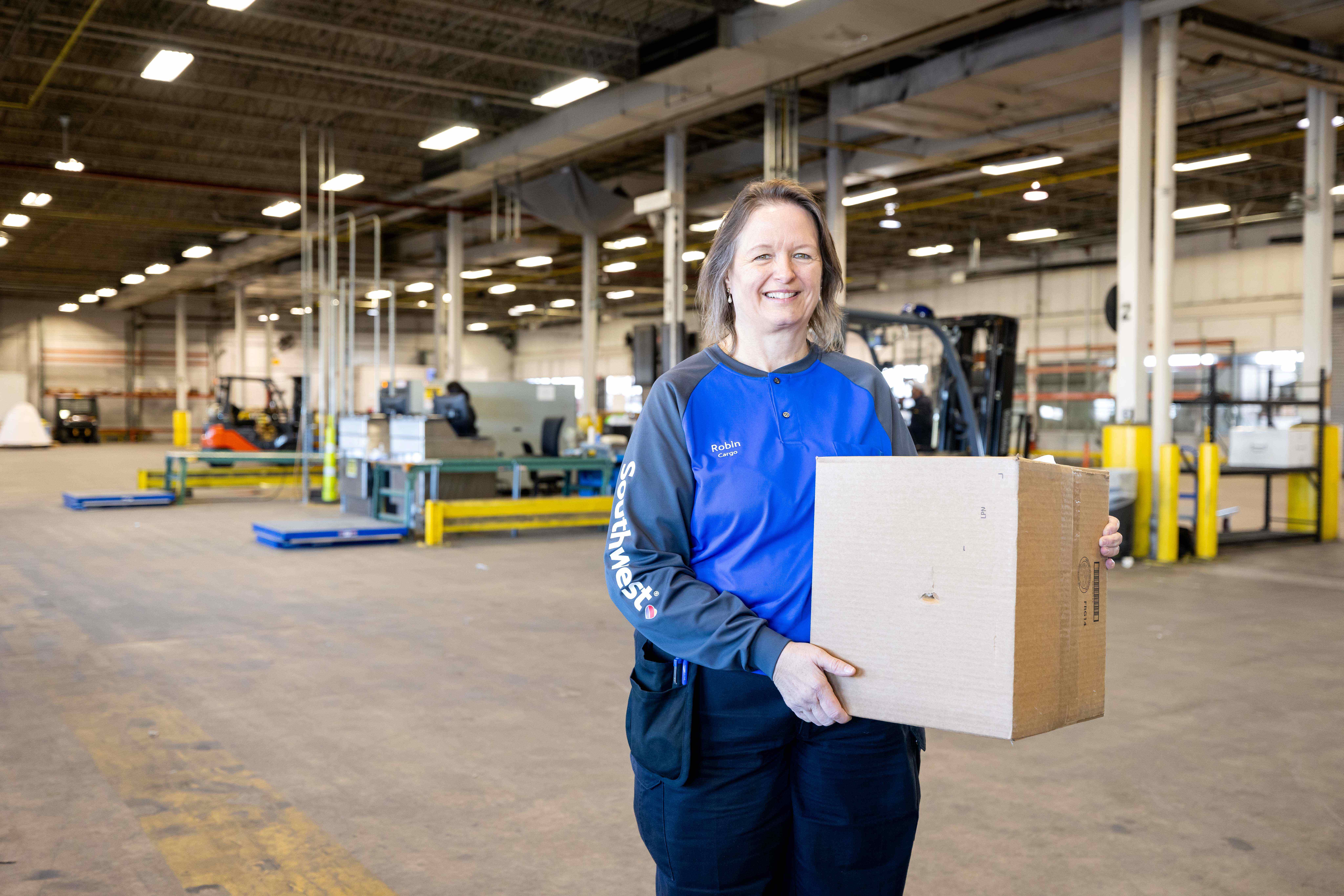 Southwest Cargo Agent smiling holding cargo.