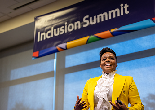 Woman speaking on stage at the Inclusion Summit