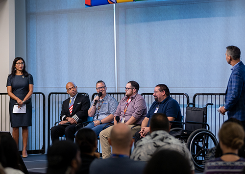 Six people on the stage speaking at an Inclusion Summit