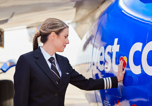 A woman smiling and inspecting a plane