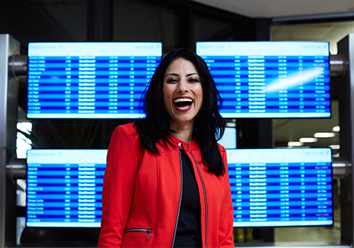Flight Attendant smiling in front of a route map