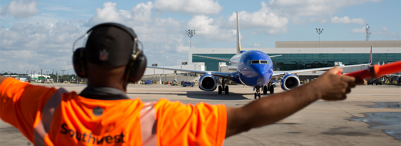 Ramp agent marshalling a Southwest plane at the airport
