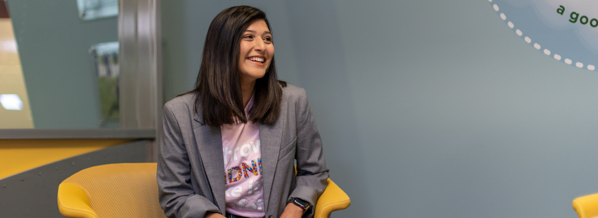 A woman smiling and working on her laptop