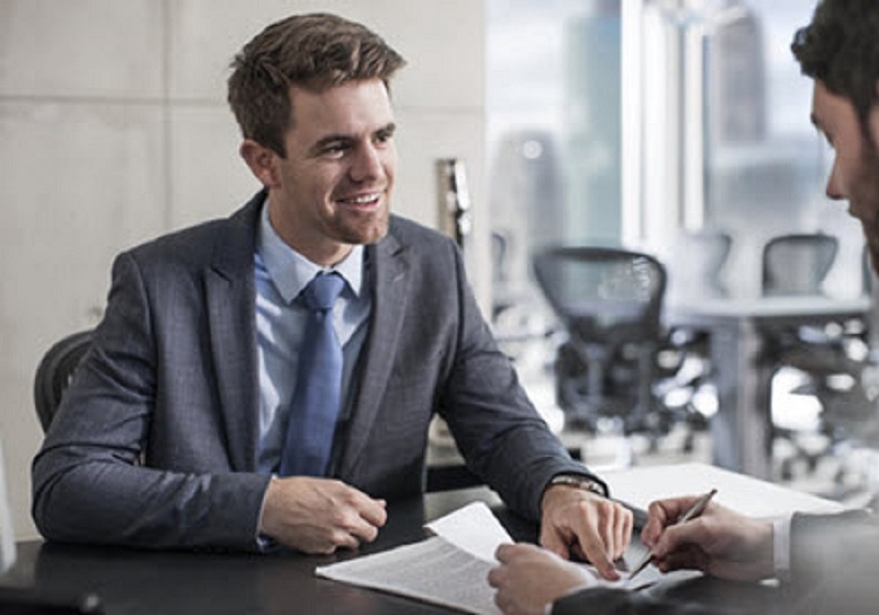 Two men reviewing loan documentation