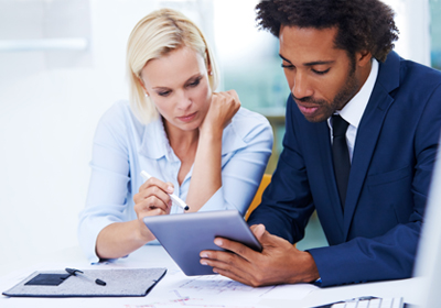 Co-workers reviewing customer data on tablet