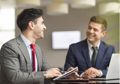 Two businessmen negotiating and smiling with each other 