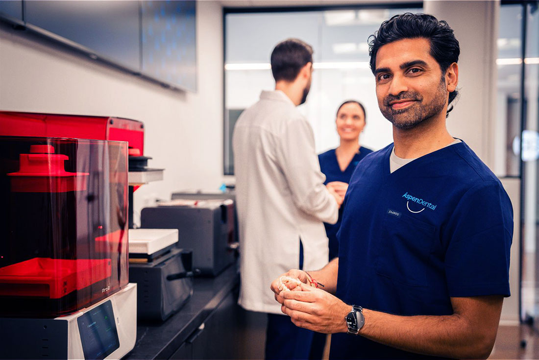 Front office worker smiling, pointing at the viewer