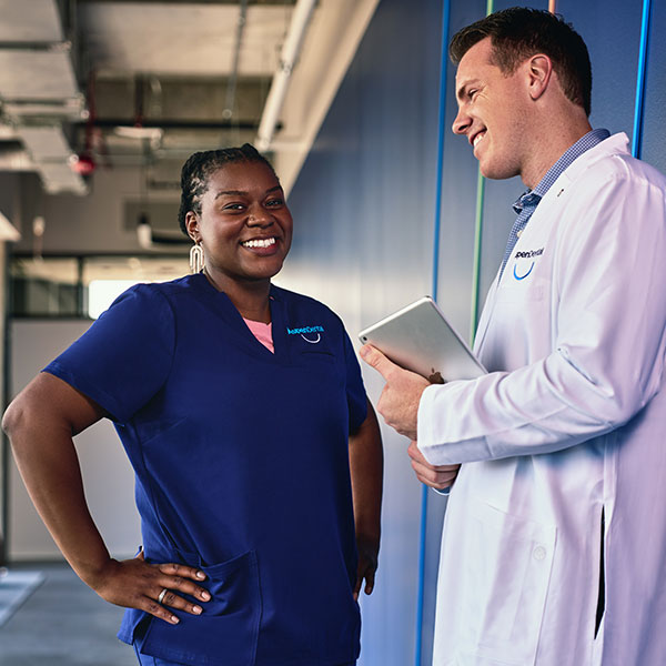 Instructor and student having a light hearted conversation in the halls of TAG U