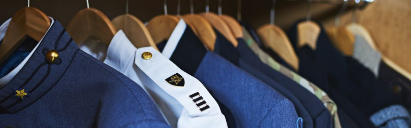 A close up of military uniforms hung up in the closer to represent retirement. 