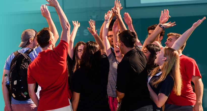 Members of the leadership development program raise their hands in excitement after a team cheer.