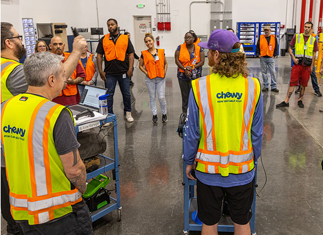 Two Chewy FC team members lifting up a Chewy box