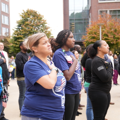 A group of Children’s staff and veterans say the national anthem during Veterans breakfast event.