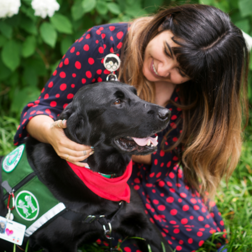 Children’s facility dog in garden with Children’s employee. 