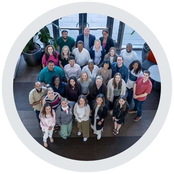 A group of employees gathered together in an office setting