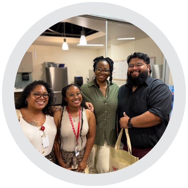 A small group of employees gathered together inside a workplace setting 