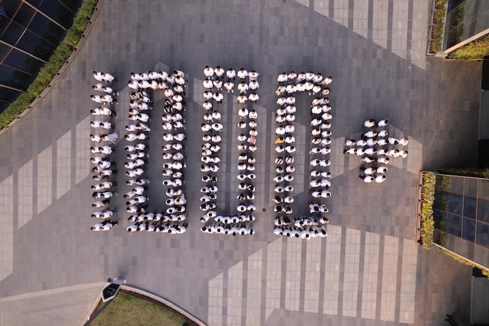 Employees standing in the shape of "1000+" to celebrate hiring 1000 employees
