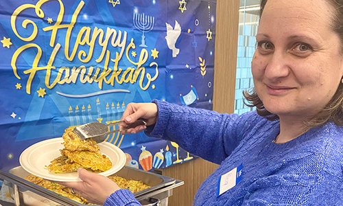 Female employee serving latkes at Hanukkah celebration