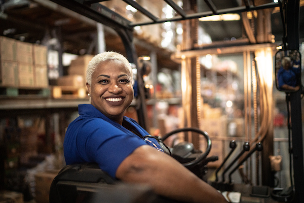 Employee smiling while working a machine